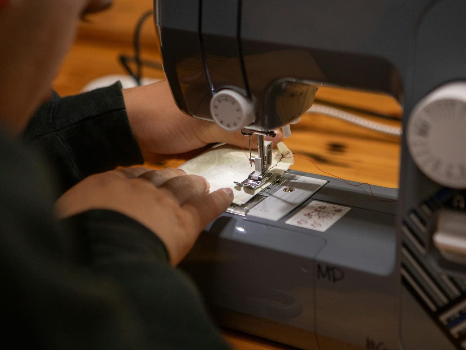 Kids learning to use a sewing machine at a Brooklyn summer sewing camp.