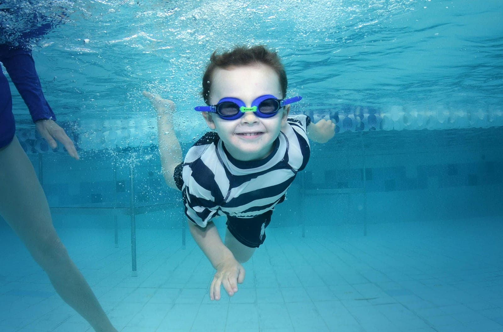 Kids learning freestyle in an outdoor pool at a Brooklyn summer swim camp.